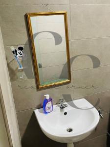 - un lavabo avec miroir et une bouteille de savon dans l'établissement Creative Corner, à Cyberjaya