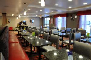 a dining room with tables and chairs in a restaurant at Chateau Inn & Suites Bonnyville in Bonnyville