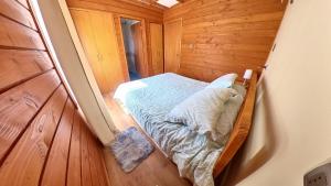 a small bedroom with a bed in a wooden room at Habitación con Baño Privado en Casa Central Villarrica in Villarrica