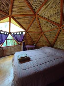 a bed in a room with a wooden ceiling at Casa Arbol Domos in Cafayate