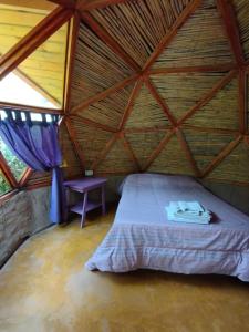 a bed in a room with a wooden roof at Casa Arbol Domos in Cafayate