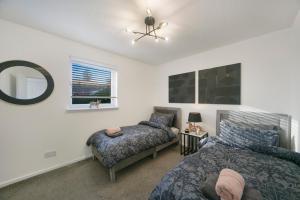 1 dormitorio con 2 camas y espejo en Bohemian Raphsody Apartment ✪ Grampian Lettings Ltd en Aberdeen