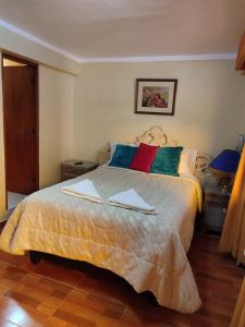 a bedroom with a large bed with towels on it at Krusty Hostel II in Huaraz