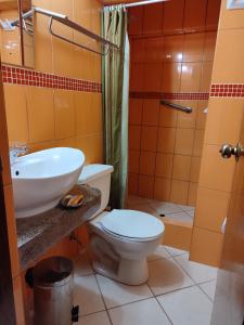 y baño con aseo, lavabo y ducha. en Krusty Hostel II, en Huaraz