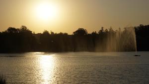 una puesta de sol sobre un lago con un barco en el agua en Departamento en Tandil - Céntrico en Tandil