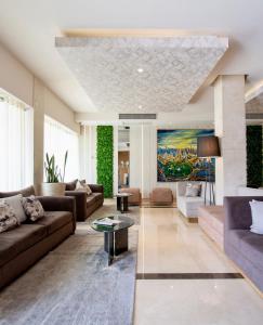 a living room with couches and a painting on the wall at Hotel Plaza Diana in Guadalajara