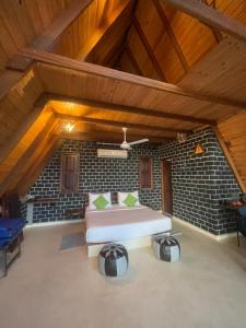 um quarto grande com uma cama e uma parede de tijolos em The Cloud Resort em Kadugannawa