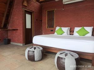 a bedroom with a large bed and a brick wall at The Cloud Resort in Kadugannawa