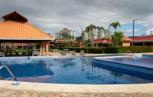 a large swimming pool in a resort with buildings at Couples Condo B42 1BR Pool Jacuzzis Covered Terrace Walk to Ocean and Dining Secure Complex in Jacó