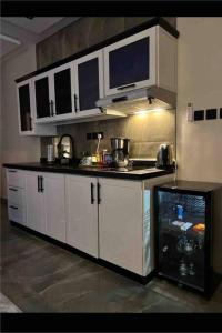 a kitchen with white cabinets and a black counter top at شقة جديدة بتصميم فاخر نظام مودرن in Riyadh