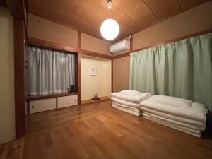 a room with two beds in it with a window at 貸切宿KUMANO in Miyazaki