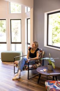 a woman sitting in a chair in a room at Haka House Queenstown Lakefront in Queenstown