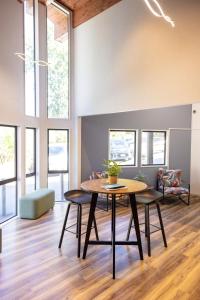 a dining room with a table and chairs and windows at Haka House Queenstown Lakefront in Queenstown