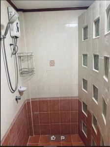 パタヤ・サウスにあるPauna Inn Pattayaの赤と白のタイル張りのバスルーム(シャワー付)