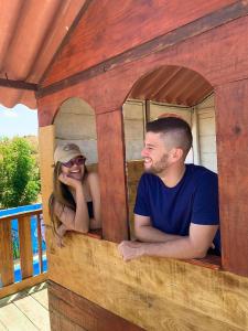 a man and a woman sitting in a play house at Pousada Bugaendrus in Touros