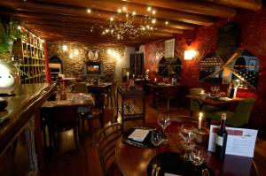 a restaurant with tables and chairs and a chandelier at Auberge De Maison Rouge in Vétraz-Monthoux