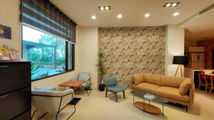 a living room with a couch and chairs at Riverbank Villa in Luodong