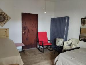 - une chambre avec deux chaises, une porte et un lit dans l'établissement Beach Cat 3, à Cancún