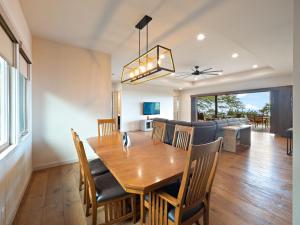a dining room and living room with a table and chairs at Kukui Hale at Makalei Estates in Kailua-Kona