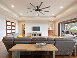 a living room with a couch and a ceiling fan at Kukui Hale at Makalei Estates in Kailua-Kona