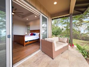 a screened in porch with a bed and a couch at Kukui Hale at Makalei Estates in Kailua-Kona