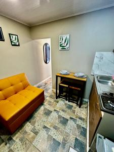 een woonkamer met een oranje bank en een tafel bij Aparta estudio cerca al aeropuerto el Dorado in Bogota