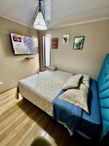 een slaapkamer met een bed met blauwe lakens en een raam bij Aparta estudio cerca al aeropuerto el Dorado in Bogota