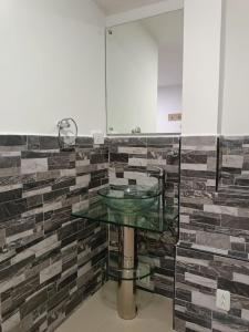 baño con lavabo de cristal y pared de ladrillo en HOTEL CASA GIRARDOT en Medellín