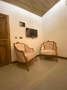 2 sedie sedute in una stanza con TV di konak esila a Uşak