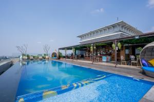a pool at a resort with a bar at Belviu Hotel Bandung in Bandung