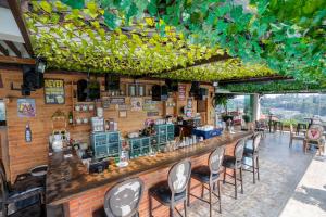 a bar in a restaurant with chairs around it at Belviu Hotel Bandung in Bandung