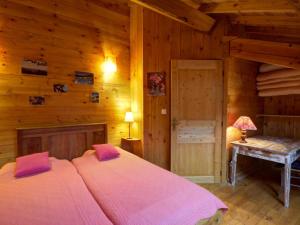 ChevelièreにあるMaison en pierre avec sauna et jardin à Chalmazel - FR-1-496-39の木製の部屋に大型ベッドが備わるベッドルーム1室が備わります。