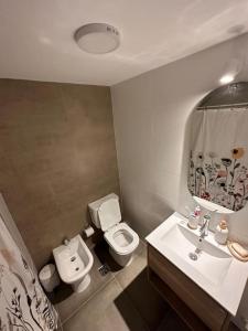 a bathroom with a white toilet and a sink at Moderno apartamento súper equipado ! in Montevideo