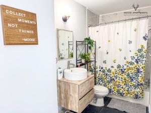 a bathroom with a sink and a shower curtain with flowers at The Moose #12 - Brand New Modern Luxe Loft with Free Parking, King Bed & Fast WiFi in Memphis