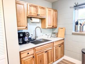 a kitchen with wooden cabinets and a sink at The Moose #12 - Brand New Modern Luxe Loft with Free Parking, King Bed & Fast WiFi in Memphis