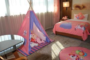 un dormitorio con una tienda de campaña con animales de peluche en Jinling Grand Hotel Nanchang, en Nanchang
