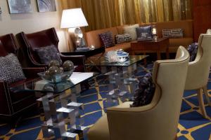Renaissance Dallas Hotel في دالاس: غرفة معيشة مع طاولة وكراسي