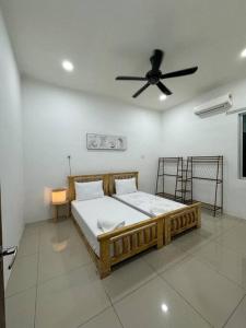 Schlafzimmer mit einem Holzbett und einem Deckenventilator in der Unterkunft Roxy homestay in Alor Setar