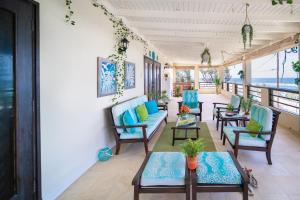 a room with chairs and tables and a balcony at Hidden Gem Barbados in Christ Church