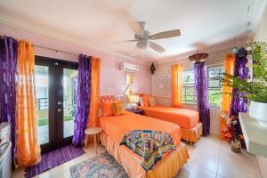 a bedroom with two beds and a ceiling fan at Hidden Gem Barbados in Christ Church +27 photos