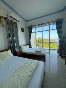 a hotel room with two beds and a large window at Tien Vuong hotel in Thiện Chánh (1) +71 photos