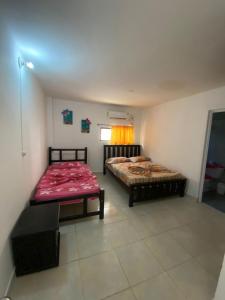 1 dormitorio con 2 camas y mesa. en HERMOSA CASA CAMPESTRE EN SANTA MARTA en Santa Marta