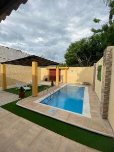 ein großer Pool in einem Hof mit einem Haus in der Unterkunft HERMOSA CASA CAMPESTRE EN SANTA MARTA in Santa Marta