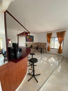 una sala de estar con un bar con taburetes. en HERMOSA CASA CAMPESTRE EN SANTA MARTA en Santa Marta