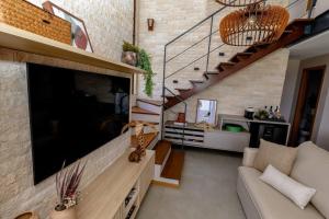 Uma TV ou centro de entretenimento em Casa 19 da Vila Beija Flor