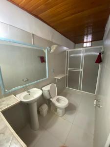 uma casa de banho com um WC e um lavatório em HERMOSA CASA CAMPESTRE EN SANTA MARTA em Santa Marta