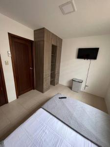 薩利納斯的住宿－Casa con piscina Punta Carnero，一间卧室配有一张床和一台电视
