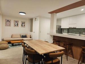 cocina y sala de estar con mesa de madera y sillas en Hermoso dúplex con gran vista!, en Pucusana