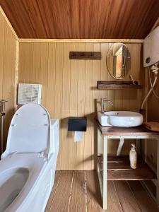a bathroom with a toilet and a sink at Nhà Bên Suối - Homestay & Camping in Da Lat