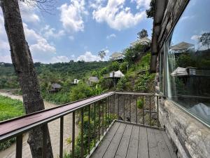 uma varanda de uma casa com vista em Nhà Bên Suối - Homestay & Camping em Da Lat